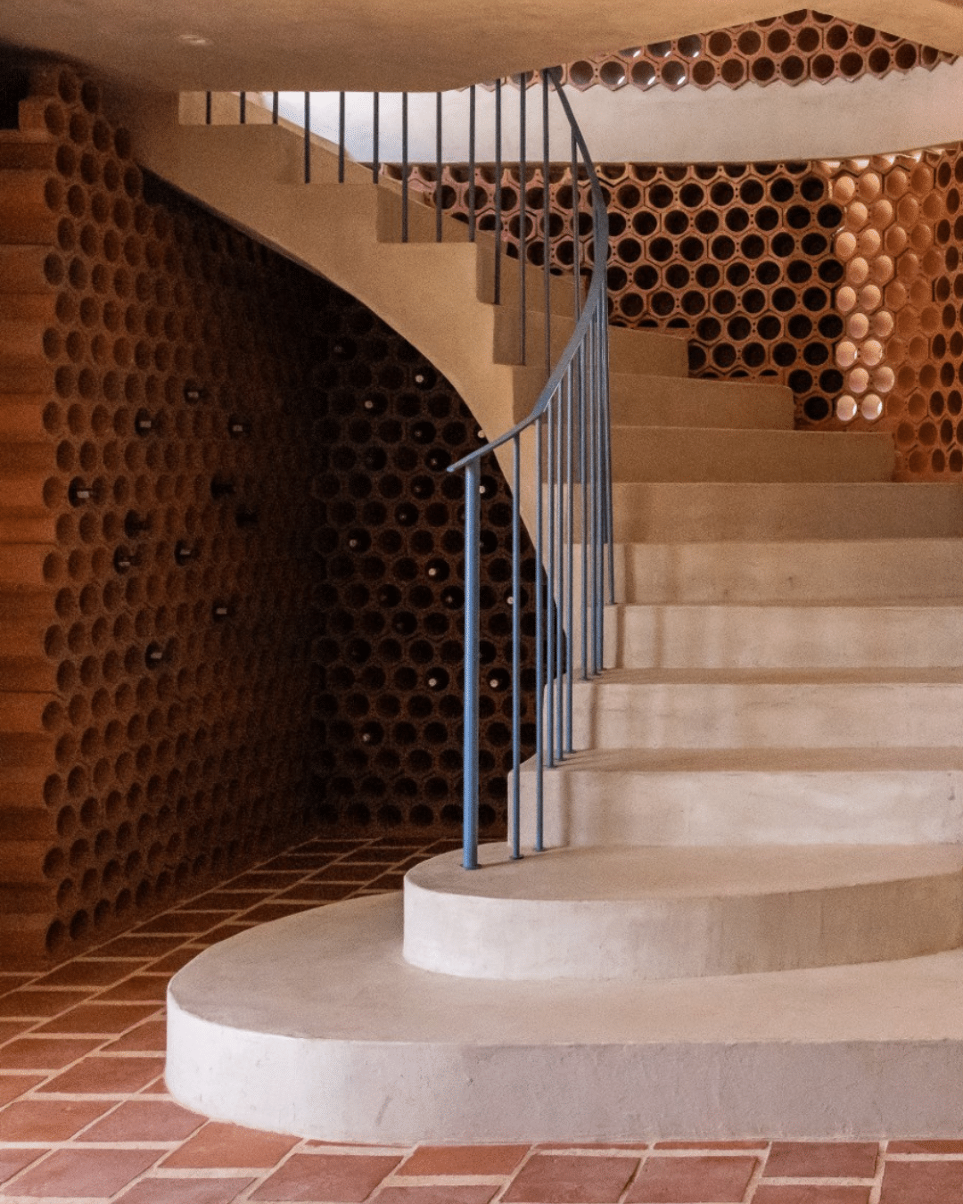 Klay terracotta wine racks stacked in wine cellar under a staircase at luxury guest house